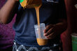 Edith Ndebele fills a plastic jar with peanut butter