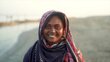 A smiling woman in a colourful headscarf backdropped by a wide river. Photo: WFP/Mehedi Rahman