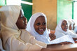 A classroom of smiling little girls in white headscarves. Photo: WFP/Maryam Madan Ali