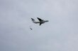 A WFP aircraft drops bags of food as it flies through cloudy skies. Photo: WFP/Eulalia Berlanga