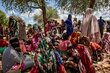 A crowd of women in long, colorful robes, await nutrition treatment at South Sudan's Wedweil Refugee Settlement. Photo: WFP/Gabriela Vivacqua