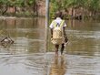 A boy wades through floodwaters in the Democratic Republic of the Congo. Photo: WFP/Benjamin Anguandia