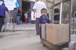 WFP/ Jaber Badwan A child stands next to the food parcel his father just collected from a WFP distribution point