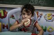 A young girl eating bread distributed by WFP at UNRWA school that is a designated shelter in times of emergency.