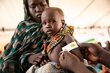 In this photo Julia (18) and her one-year-old son Mubarak attend the WFP funded nutrition clinic at the Renk transit camp in Upper Nile. Mubarak gets his MUAC tested. He is moderately malnourished.