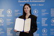 Photo: WFP/Korea. Moon So-ri, WFP Goodwill Ambassador, smiles while holding the ED Cindy McCain's Welcome Letter. 