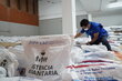A WFP staff member prepares food baskets for distribution to households affected by the earthquake