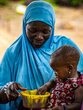 A 10-month-old girl puts her hand in the plate containing the fortified porridge to drink it by hand.  © WFP/Cheick Omar Bandaogo