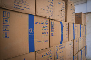 WFP-labelled cartons of fortified sunflower oil stacked in a warehouse, ready for distribution to families receiving humanitarian assistance.
