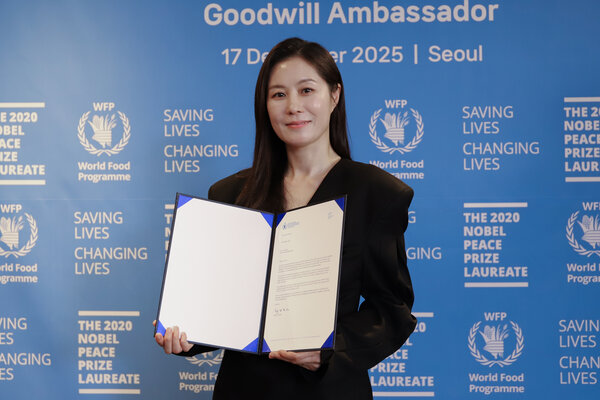 Photo: WFP/Korea. Moon So-ri, WFP Goodwill Ambassador, smiles while holding the ED Cindy McCain's Welcome Letter. 