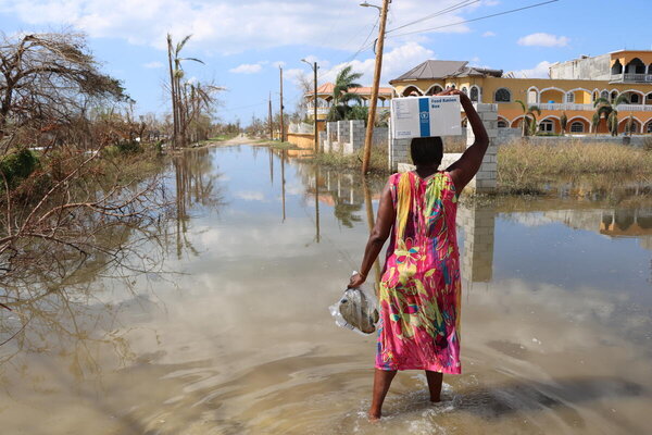 Photo: WFP/Alexis Masciarelli, a woman returns to her house carrying a box of WFP emergency food on her head, after a distribution in support of the emergency response of the government of Jamaica in the area of Arlington, St Elizabeth parish, one of the most damaged by Hurricane Melissa.