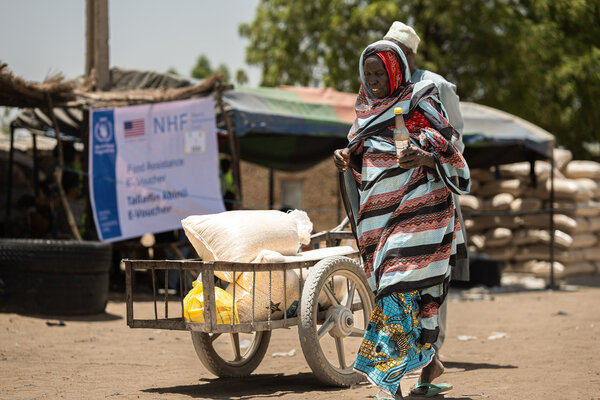 Yakura Usman, 70, receives food assistance at a distribution centre from where WFP provides life saving relief, including in-kind food rations, electronic food vouchers, and specialized nutrition support for vulnerable households and internally displaced persons in Dikwa, Borno State, Nigeria.