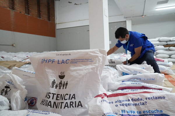 A WFP staff member prepares food baskets for distribution to households affected by the earthquake