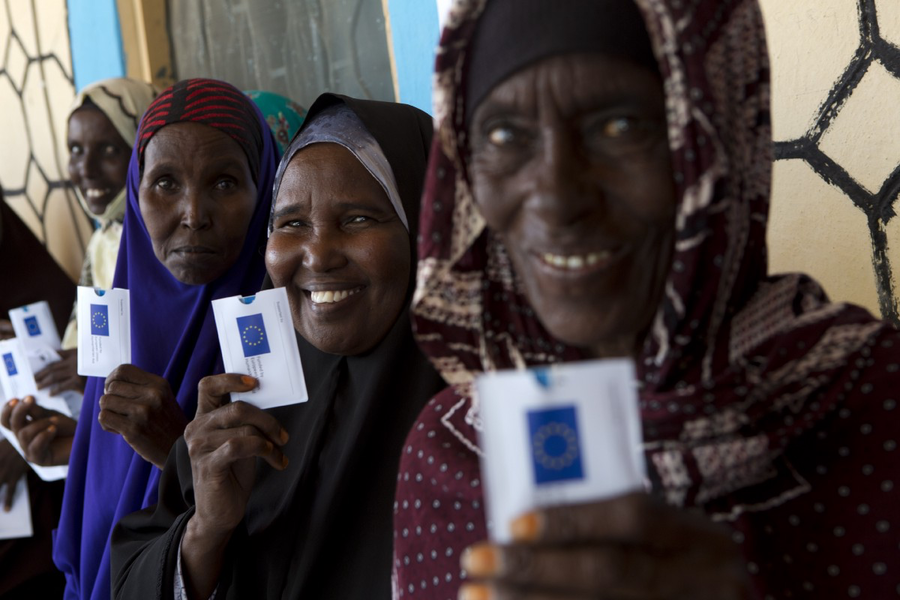 Women in Mudug Region, Somalia, holding up their cash cards