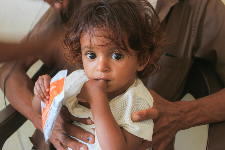 a girl is holding a package of WFP snack