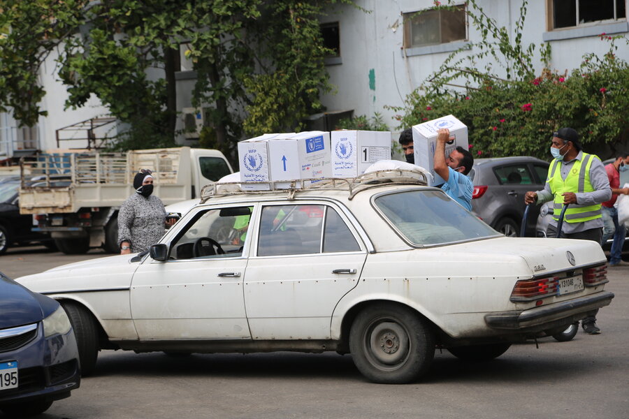 Family loading WFP assistance on top of an old car