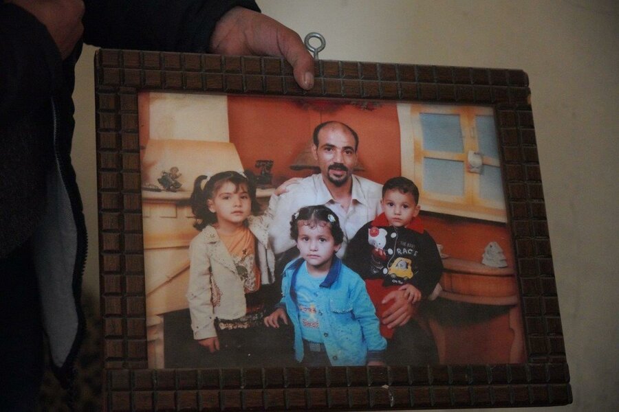 Abo Hashim hold a photo of his family and children before the conflict