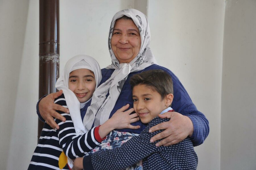 Abdulrafea's grandmother holds him and his sister