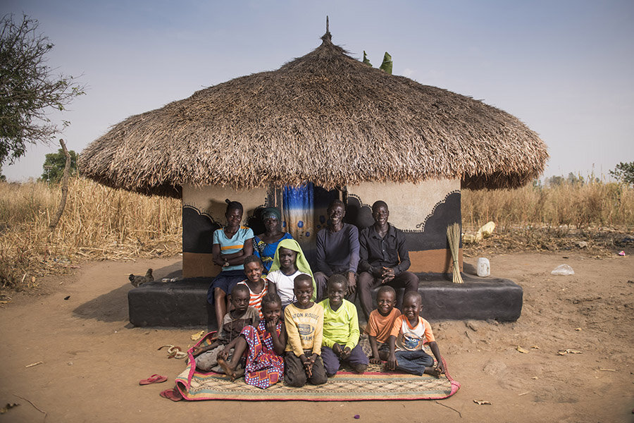 Willy Idoru, a refugee from the DRC and a member of the Jujumbu farmers group, poses for a picture with his family outside their home in the Lobule refugee settlement in northwest Uganda. Photo: WFP/ Hugh Rutherford