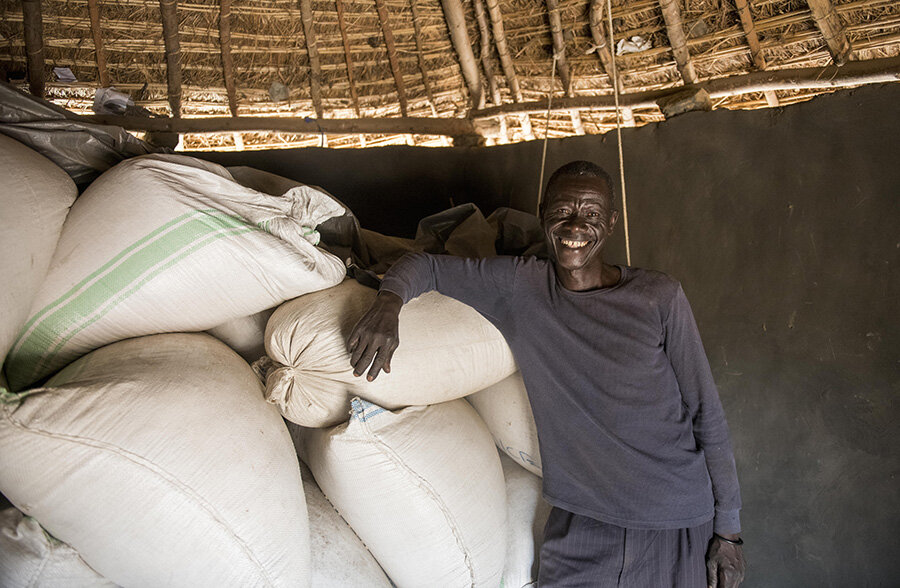 Willy Idroru, a refugee from the DRC and a member of the Jujumbu farmers group poses for a picture with the group's harvested rice in the Lobule refugee settlement in northwest Uganda. Photo: WFP/Hugh Rutherford
