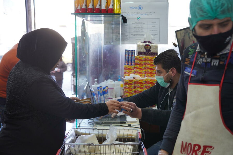 Woman pays with WFP card at a store in Syria