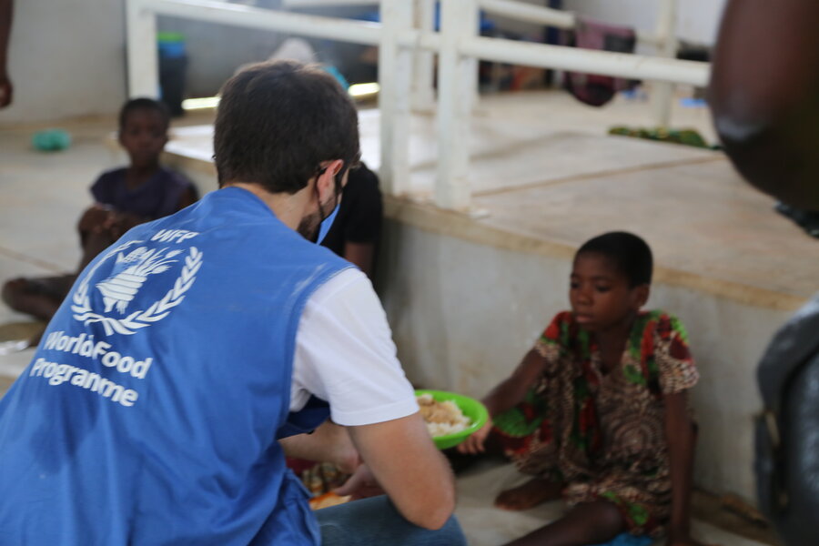 WFP staff officer distributing hot food to IDPs in Pemba sports center