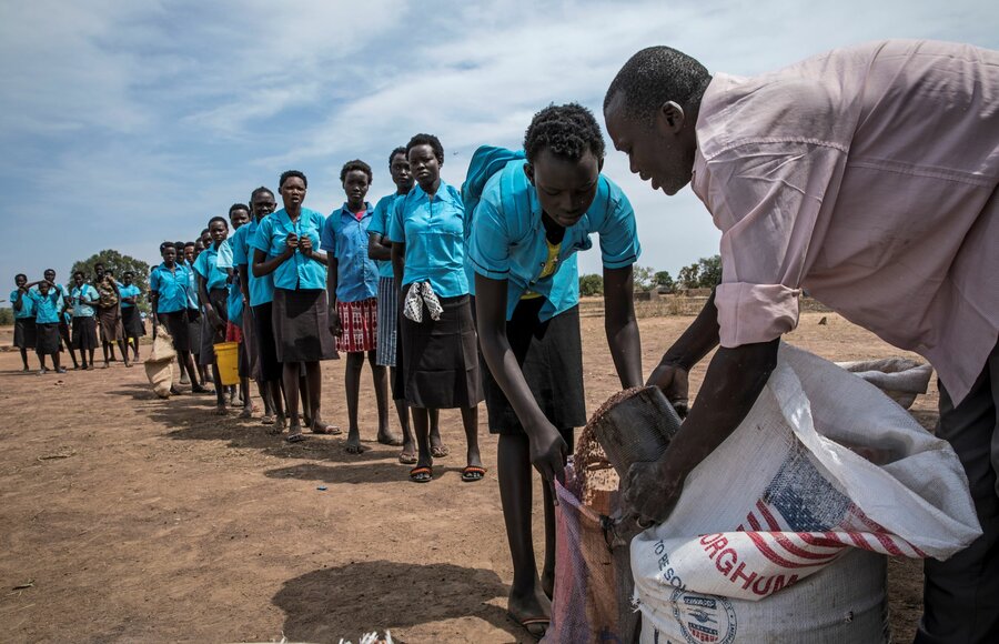 School girls receiving take-home rations at school. The girls must attend at least 80 percent of classes to receive the food. They take the rations home each month once their attendance is certified.