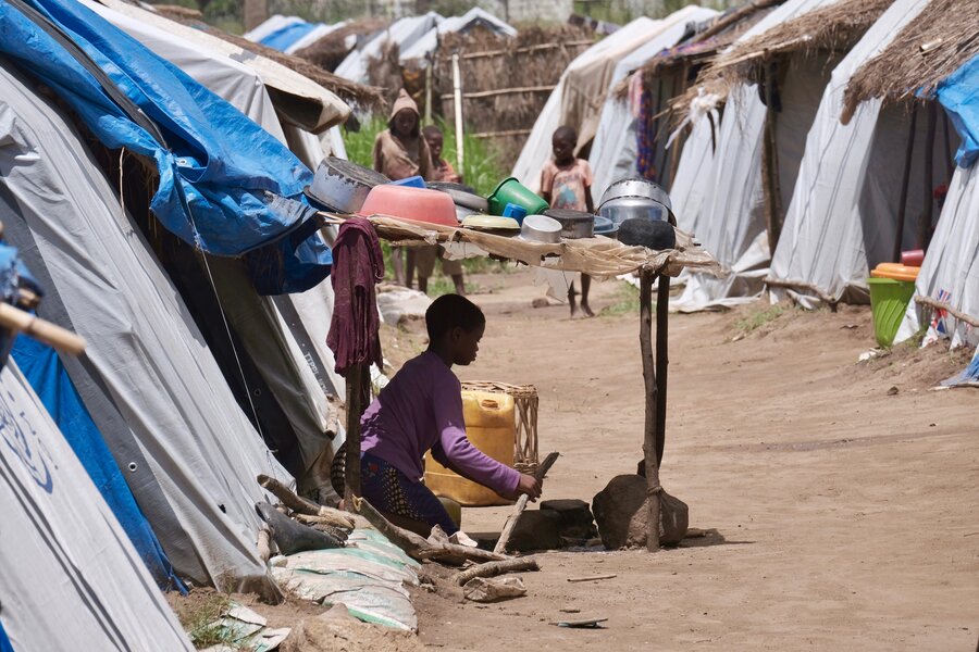 Young child sitting outside a temporary shelter