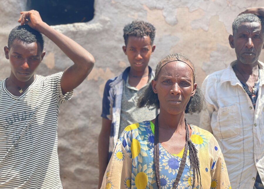 Aster and her husband Tesfay and two of their sons stand together in what remains of their home which was burned down. Four of their children escaped during the fire and they haven’t seen them since.  Photo: WFP/Claire Nevill