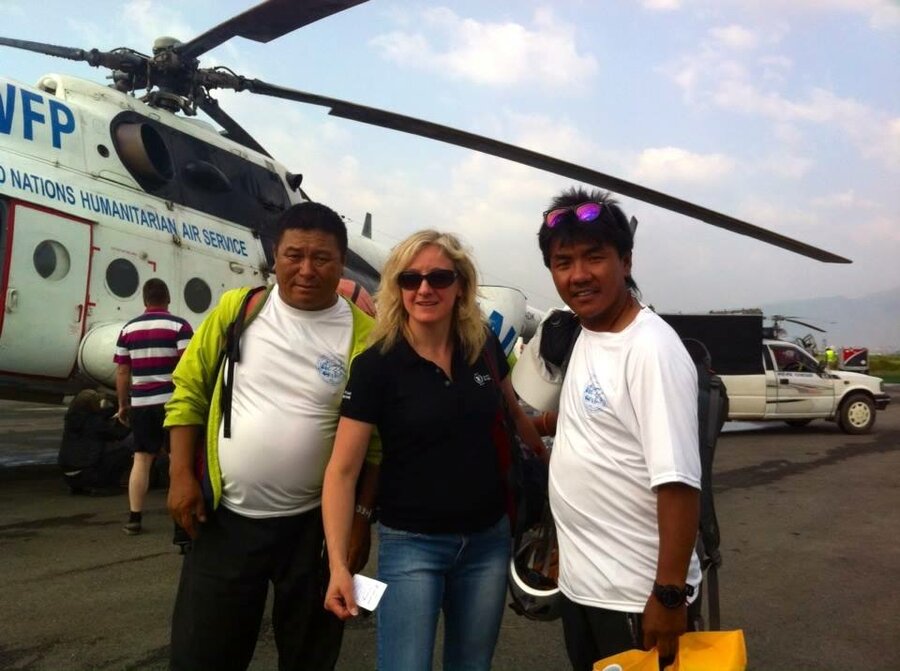 Woman and two men in front of a helicopter