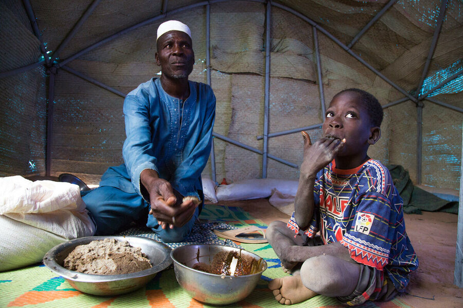 a father and his child are eating their meals