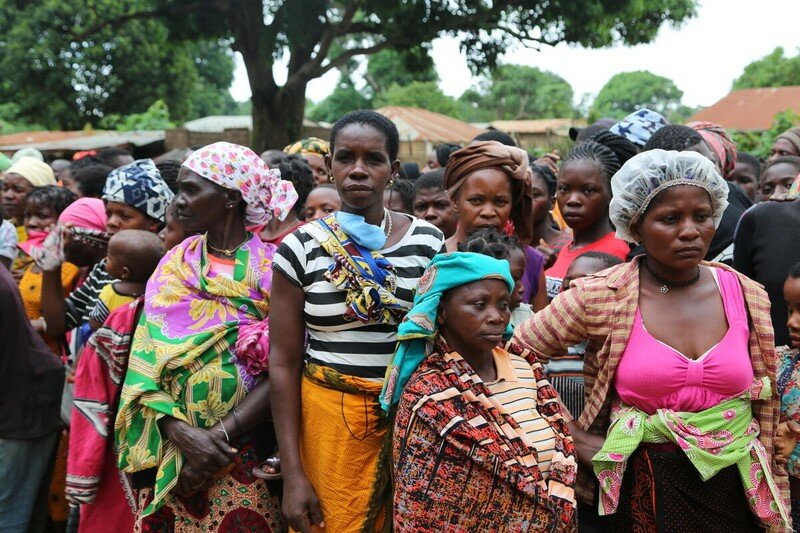 Women with solemn expressions huddled together.