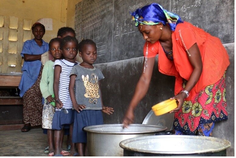 Woman serving food to children
