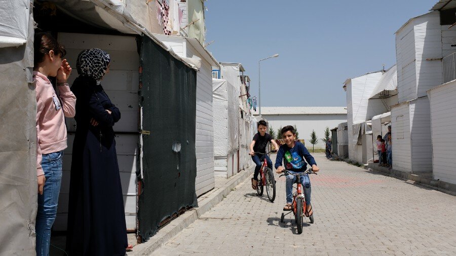 Ahmad and his siblings riding their bicycles at the camps' open space