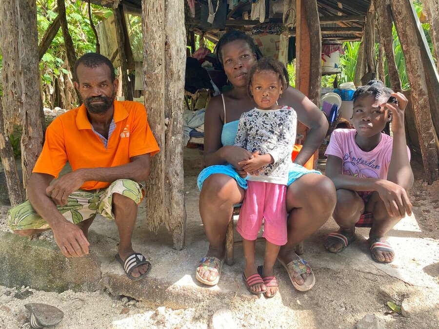 family of four sitting in front of temporary shelter