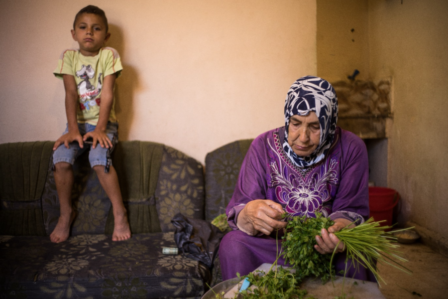 Mona’s mother prepares Tabbouleh – Lebanon’s national dish composed of parsley, burghul, tomatoes and oil. These ingredients are among the many items facing a sharp increase in prices. Photo: WFP/Giulio Origlia 