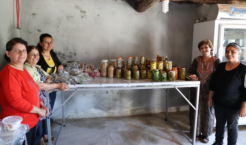 The women proudly show some of their latest products.