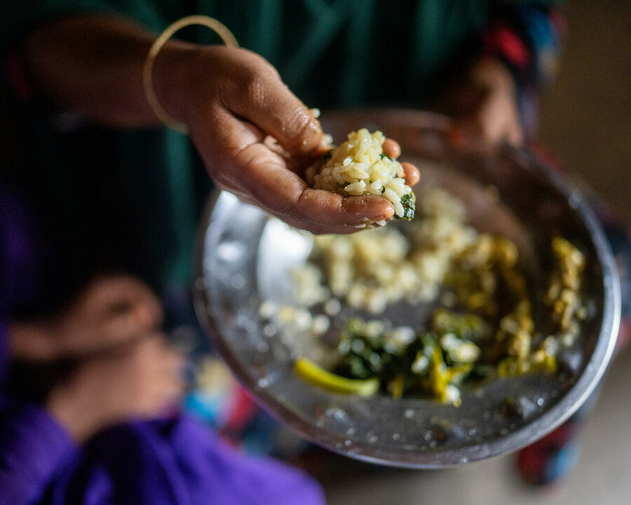 Hand holding some food from a plate