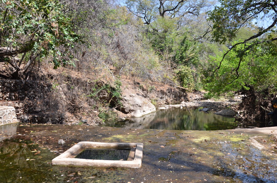 A landscape shot of the spring among a body of water and green hills.