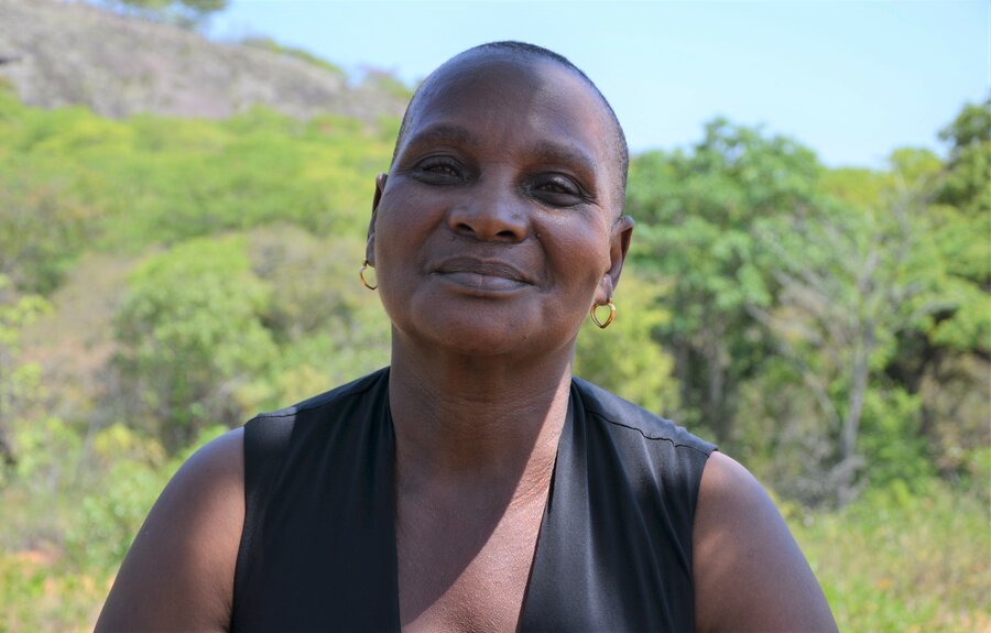 A close-up profile shot of a smiling woman.