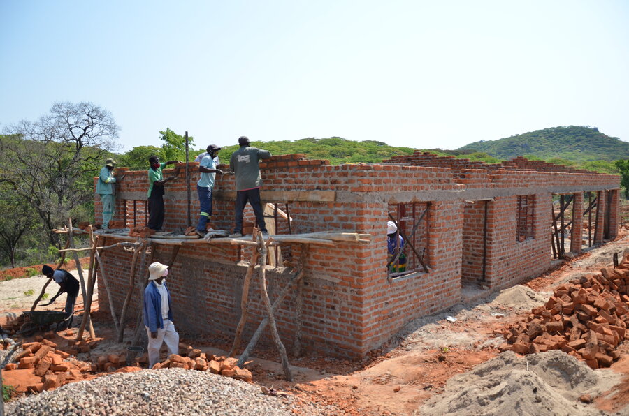 Workers constructing a brick building.