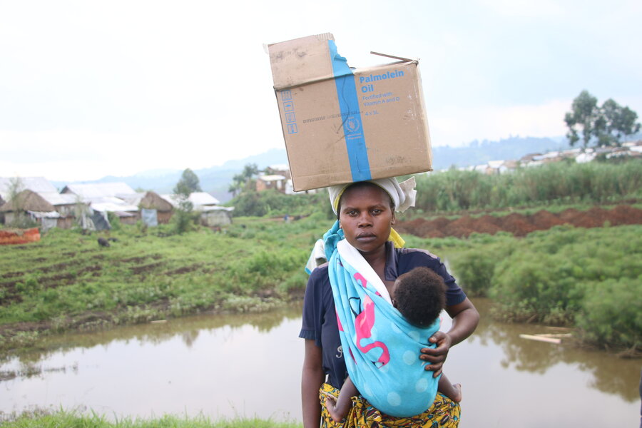Woman carrying a box of WFP food 