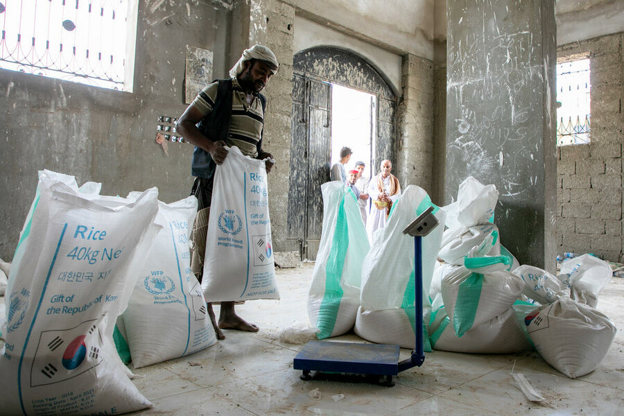 Yemen. A worker weighs bags of rice at a WFP food assistance distribution point in Hareeb