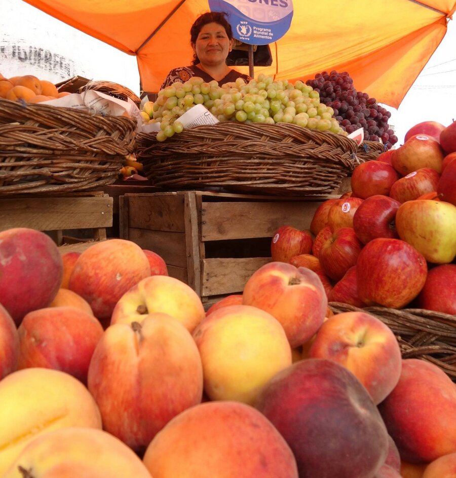 A woman sells peach on the streets of Cochabamba, Bolivia.