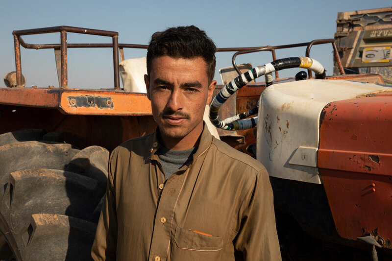 Erfan standing in front of a tractor.