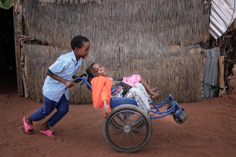 Boy with his sister who lives with a disability in Kenya