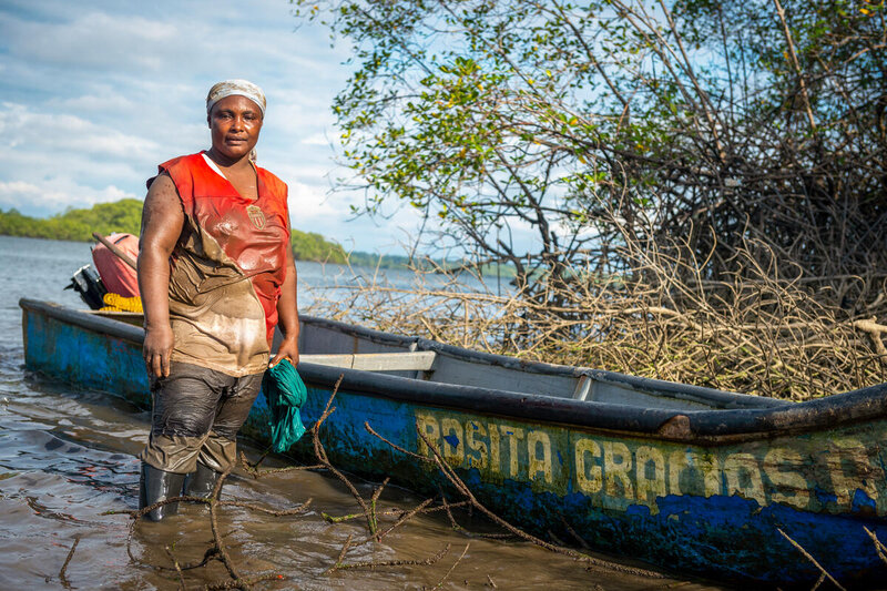 Rosa en frente de su bote llamado "Rosa Gracias a Dios" luego de un día de trabajo en el manglar.