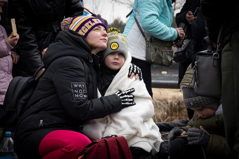 A woman and child cuddle crossing into Poland from Ukraine at Krakovets