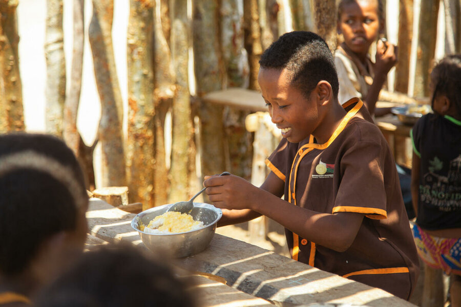 Séraphin smiles as he eats rice and lentils in the canteen. Séraphin is a beneficiary.
