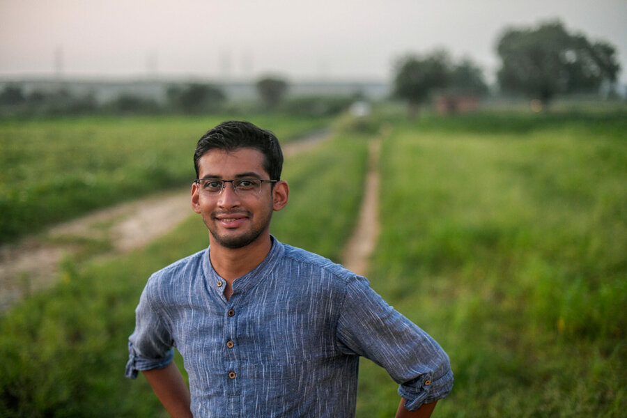 Vidyut stands in a field smiling with his hands on his hips